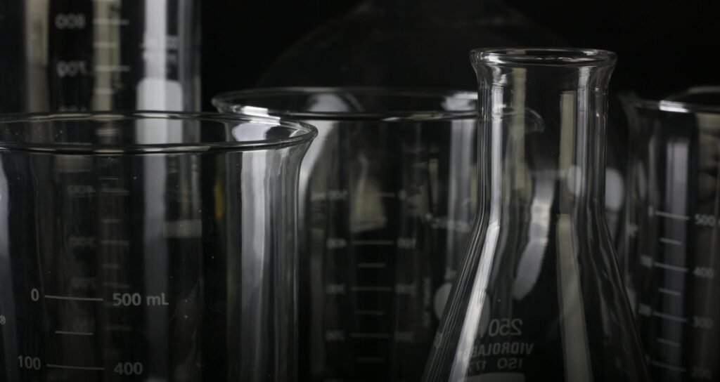 A detailed close-up of various transparent laboratory glassware used in scientific experiments.
